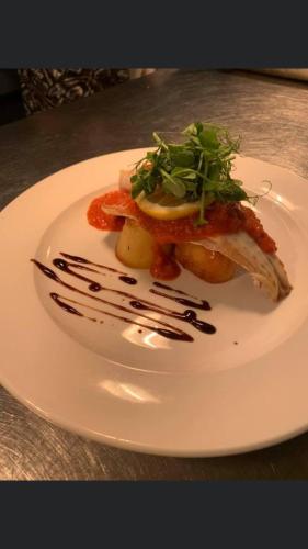 a white plate with food on a table at Mendip Spring Golf and Country Club in Churchill