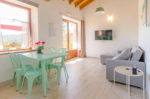 sala de estar con mesa, sillas y sofá en Apartamentos Rurales Las Garzas de Oyambre en San Vicente de la Barquera