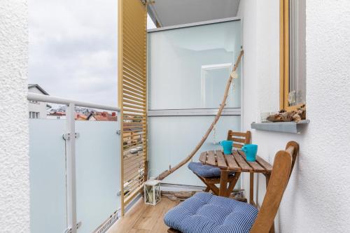 a small balcony with a table and a chair at Marine Apartment 9B by Renters in Dziwnówek