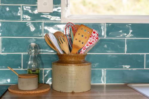 un recipiente de utensilios de cocina en una encimera en Boho Cottage, en White Beach