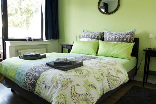 a bedroom with a large bed with green walls at 500 Miles Apartments in Bonn