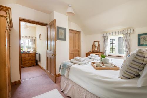 a bedroom with a large white bed with towels on it at Marris Cottage in Grimsby