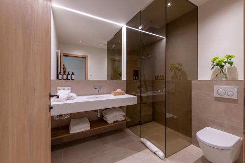 a bathroom with a sink and a shower and a toilet at Brunnenhof Luxury Apartments in Lech am Arlberg