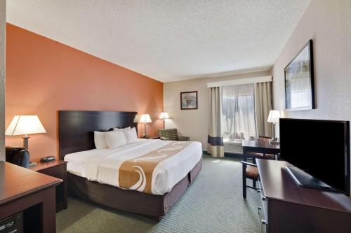 a hotel room with a bed and a flat screen tv at Quality Inn in Cedar Park