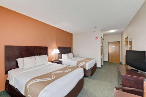 a hotel room with two beds and a flat screen tv at Quality Inn Cedar Park - Austin Northwest in Cedar Park