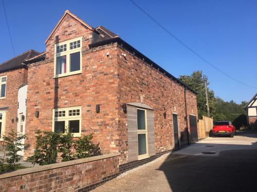 a brick building with a car parked in front of it at The Old Coach House in Polesworth
