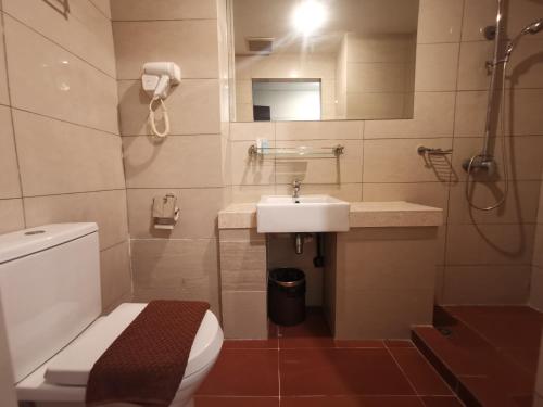 ein Bad mit einem WC, einem Waschbecken und einer Dusche in der Unterkunft Hotel De Leon II in Lahad Datu