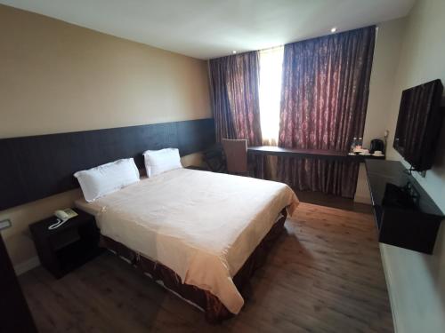 a bedroom with a large bed and a window at Hotel De Leon II in Lahad Datu