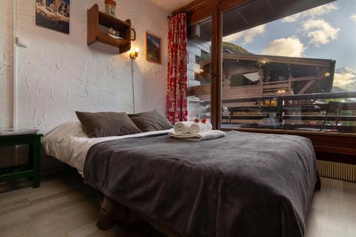 1 dormitorio con cama y ventana grande en Résidence Améthystes D4 ski in ski out - Happy Rentals, en Chamonix-Mont-Blanc