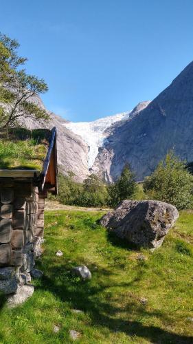 a large stone wall with a mountain range behind it at Oldevatn Camping in Olden