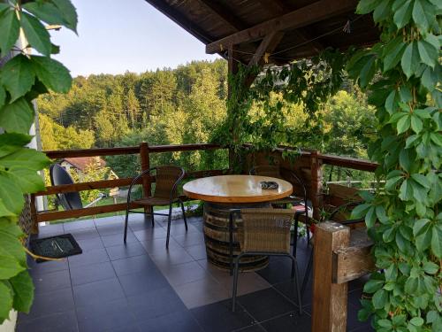 a patio with a table and chairs on a balcony at Country House Roman in Doboj