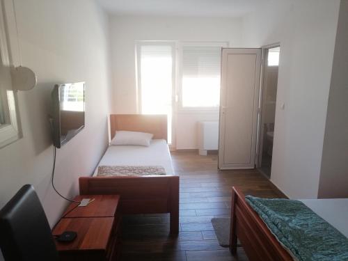 a small room with two beds and a table at Vaš Kutak 2026 - Sobe Lux za izdavanje in Obrenovac