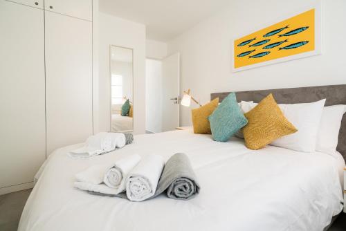 a bedroom with a white bed with towels on it at Waterside Village - Sea View Apartment in Alagoas