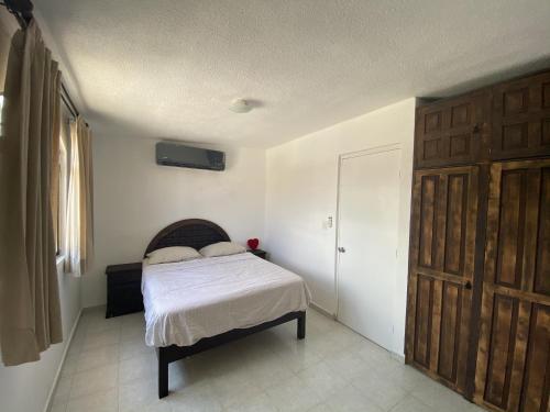 Un dormitorio con una cama y una puerta de madera. en flower of life, en Cancún
