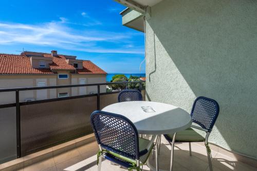 einen Tisch und Stühle auf einem Balkon mit Meerblick in der Unterkunft Studio Apartments Apolonia in Novalja