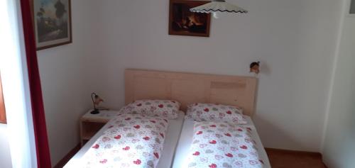 two beds in a small room with a bedspread and a table at CASA IDA - ClPAT 22253 in Tregiovo
