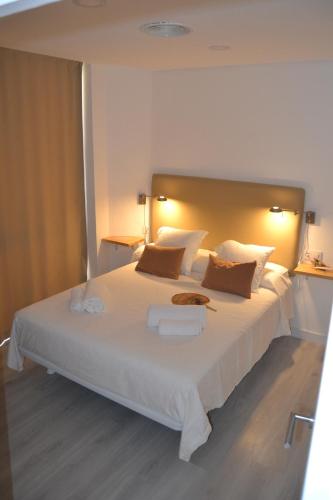 een slaapkamer met een groot bed met witte lakens en kussens bij Torre de Campanas in Córdoba