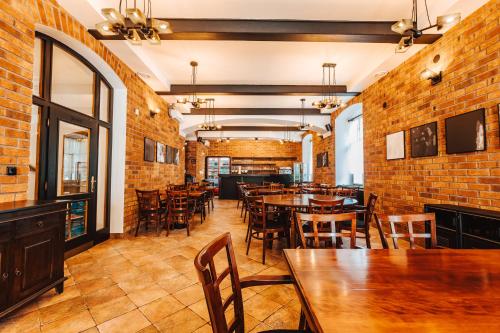 a restaurant with wooden tables and chairs and brick walls at Hotel U Valdické brány in Jičín