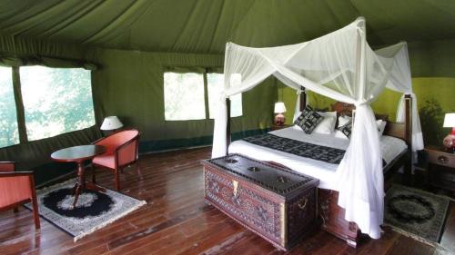 een slaapkamer met een hemelbed in een tent bij Osero Lodge in Ololaimutiek