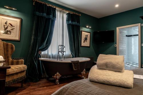 a bathroom with a tub and a chair at The Coach and Horses in Clitheroe