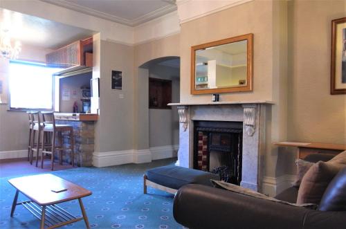 a living room with a couch and a fireplace at Hylands in Nottingham