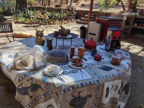 een tafel met een tafelkleed met voedsel erop bij Bosveldsig Cottages in Modimolle