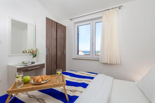a bedroom with a table with a bowl of bread on it at Villa Romana and Tea in Šilo