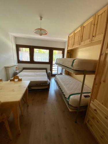 a room with two bunk beds and a table at Christian's apartments in Breuil-Cervinia