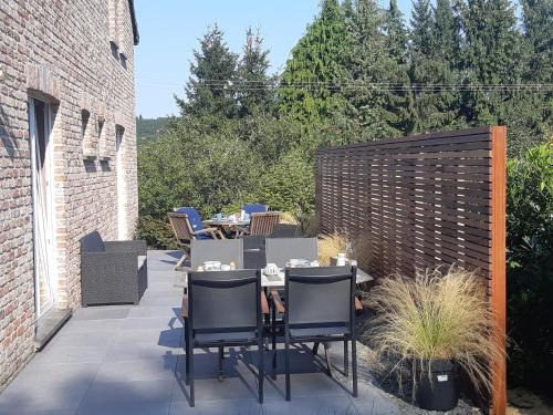 a patio with a table and chairs and a fence at B&B Caprice d'Epices in Francorchamps