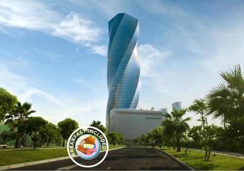 a tall glass building with a road in front of it at Wyndham Grand Manama in Manama