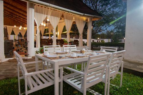 a white table and chairs in front of a building at Villa Ameera Malindi in Malindi