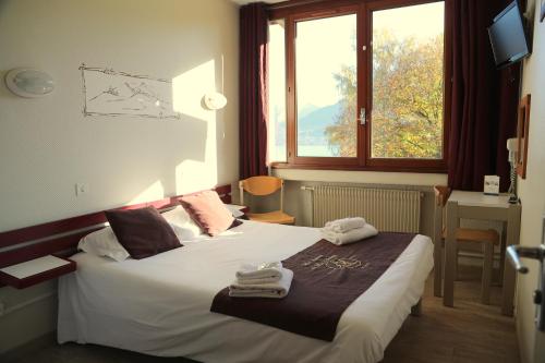 a hotel room with a bed with towels on it at Village Club Les Balcons du Lac d'Annecy - Neaclub in Sévrier