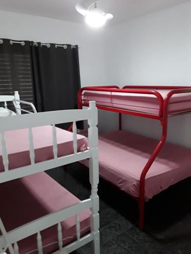 kilka łóżek piętrowych w pokoju w obiekcie APARTAMENTO EM PRAIA DA ENSEADA, GUARUJÁ w mieście Guarujá