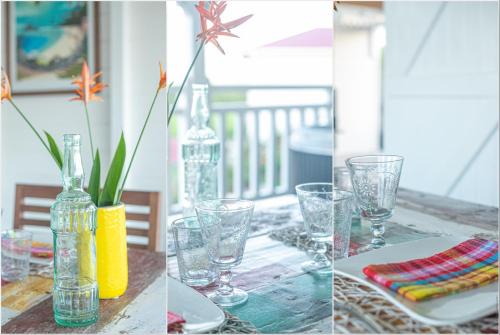 a table with glasses and a bottle on a table at Bungalow Vanille Pacane - Vue Mer avec Spa Privé in Les Trois-Îlets