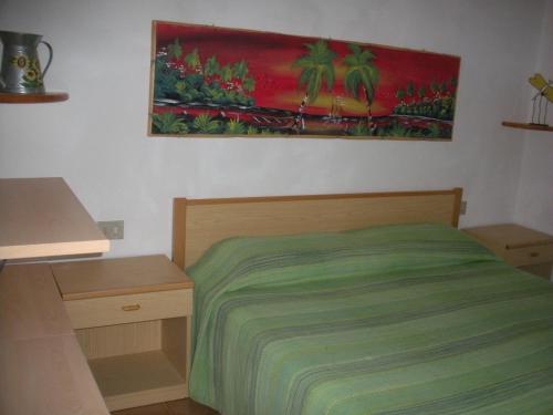 una camera da letto con un letto e un dipinto sul muro di Casa Michela a Torre Dei Corsari