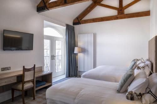 a bedroom with two beds and a desk and a tv at Markree Courtyard in Collooney