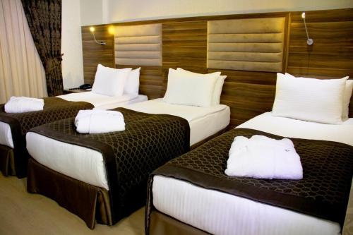 A bed or beds in a room at Adanava Hotel