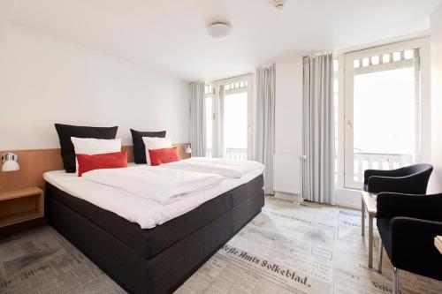 a bedroom with a large bed with red pillows at Best Western ToRVEhallerne in Vejle