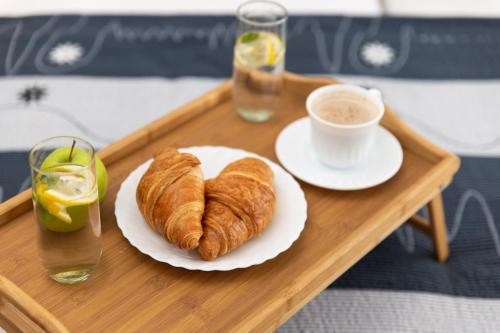 a tray with a plate of croissants and a cup of coffee at Villa Romana and Tea in Šilo