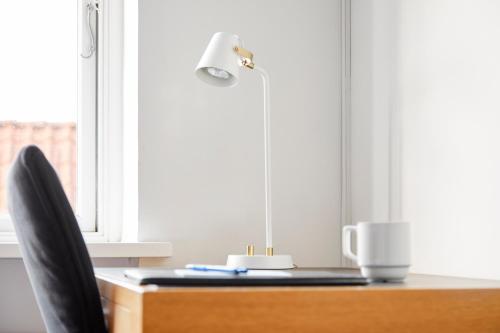 a desk with a lamp and a chair next to a window at Best Western ToRVEhallerne in Vejle