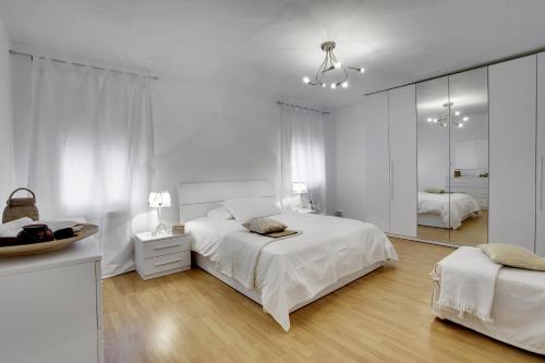 Habitación blanca con cama y espejo en La Casa Di Gemma & Regina Oriente, en Venecia