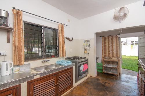 a kitchen with a sink and a stove at Villa Ameera Malindi in Malindi