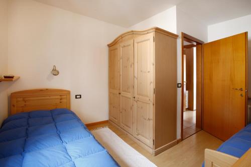 プレダッツォにあるCasa Nicoletaのベッドルーム1室(青いベッド1台、木製キャビネット付)