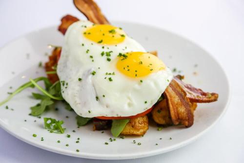 um prato com um ovo frito por cima de batatas fritas em Kisfaludy Vendégház -Sümeg- em Sümeg
