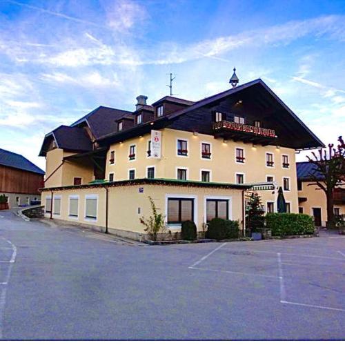 a large building with a parking lot in front of it at HartlWirt Gasthof-Hotel in Salzburg