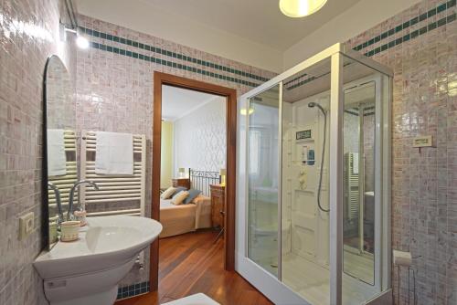 ein Bad mit einer Dusche, einem Waschbecken und einem WC in der Unterkunft Corte dei Miracoli in Venedig