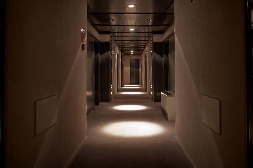 a long hallway with lights on the walls at Hotel Punt 14 in Gavà