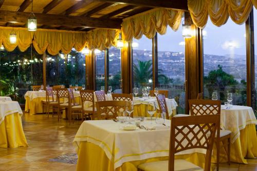 a restaurant with tables and chairs with yellow table cloth at Hotel Foresteria Baglio Della Luna in San Leone