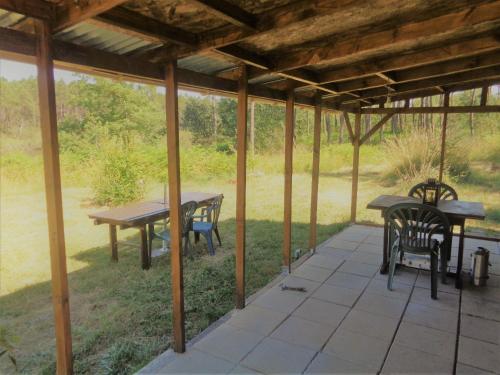 un patio avec une table et des chaises sous un pavillon dans l'établissement Cuckoo Lake Forest Cabin, à Saint-Vincent-Jalmoutiers