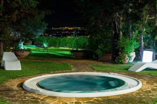 a small pool of water in a yard at night at Hotel Foresteria Baglio Della Luna in San Leone